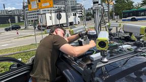TUM-Forscher Erik Leo Haß prüft die Sensorik auf dem Fahrzeug an einer Kreuzung in Garching-Hochbrück. Aus den unterschiedlichen Echtzeit-Messungen von Kameras, Lidaren und Radaren wird ein permanent aktualisiertes Bild der Verkehrssituation erstellt. (Bild: A.Schmitz / TUM)