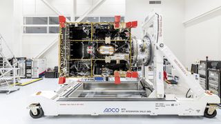 A large MTG-I satellite platform/bus in a cleanroom, mounted horizontally on an APCO Technologies “MTG S/C Integration Dolly (SID)”. The spacecraft’s internal structure, harnessing, and thermal insulation are visible, with red protective covers on multiple interfaces. (Source: OHB SE)