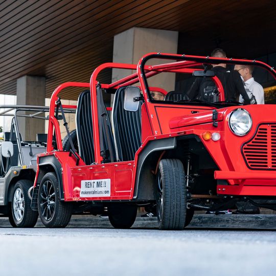 In Bonbonfarben lackiert, steht der Mini Moke neben Luxuslimousinen und Supersportwagen als Strandshuttle vor den Designhotels.(Bild:  BMW)