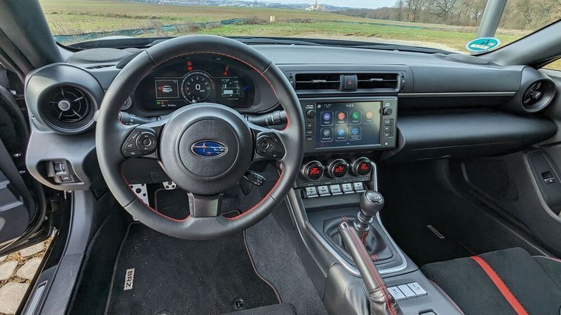 Nicht wirklich sportlich präsentiert sich das Armaturenbrett/Cockpit. Gut: Für die wichtigsten Grundfunktonen gibt es klassische Schalter bzw. Taster. Schalt- und Handbremshebel (für den Powerslide?) sind in Sachen Erreichbarkeit perfekt platziert. Die Anmutung der Materialien ist okay, mehr aber auch nicht. (Bild: Dominsky – VCG)