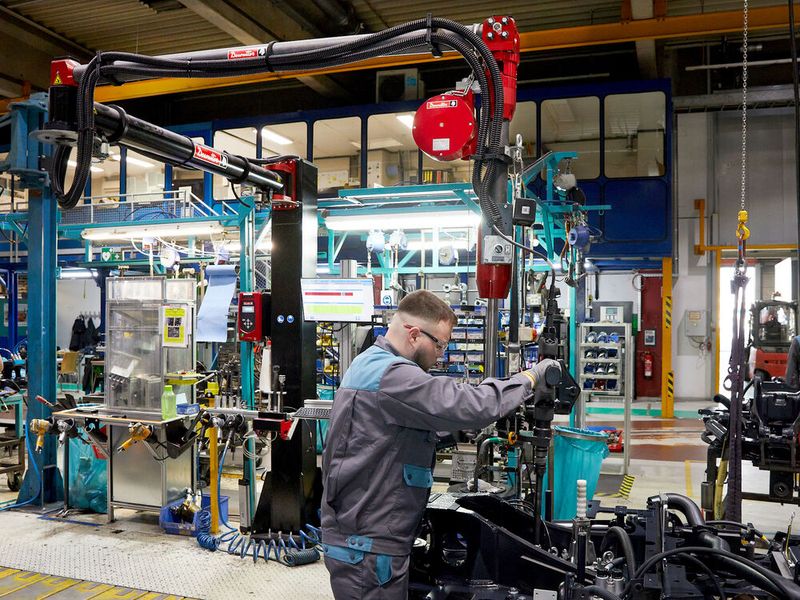Am Drehkranz der Mini- und Kompaktbagger sind rund 20 Schrauben mit jeweils etwa 300 Newtonmetern anzuziehen. Wegen der hohen Drehmomente ist das Schraubwerkzeug an dieser Station in einen „Zero Gravity“-Arm von Desoutter eingespannt. Der macht den Schrauber für den Mitarbeiter quasi schwerelos und fängt über seine Mechanik das Reaktionsmoment ab. (Bild: Desoutter / R. J. Vogel)