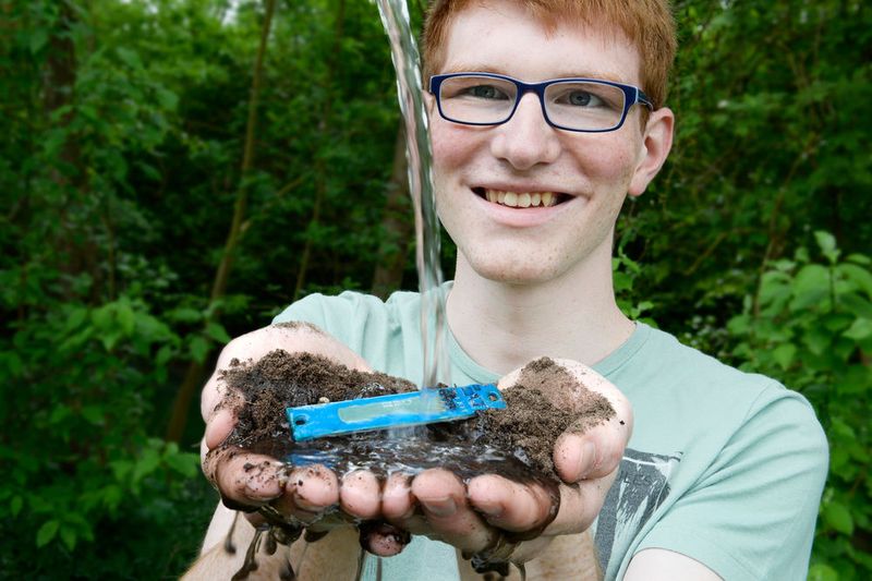 Drei Wochen Urlaub – aber wer kümmert sich um die Blumen? Die Lösung könnte eine automatische Bewässerung auf Basis eines Sensors sein, der die Bodenfeuchte misst. Lukas Kamm setzt dafür auf das Prinzip der Kapazitätsmessung: Wasser in der Umgebung von Elektroden beeinflusst dabei die Durchlässigkeit für das elektrische Feld. Um die Elektronik gegen störende Effekte abzuschirmen, brachte er das ganze System auf einer Platine auf, inklusive der Elektroden in Form kammartig ineinandergreifender Leiterbahnen. Zum Schutz gegen Feuchtigkeit schweißte er es zudem in Laminierfolie ein. Für den geplanten Einsatz bei einem EU-Forschungsprojekt, das in einem Weltraumsatelliten Tomatenwachstum erforschen will, hat er die Elektronik zudem erheblich verkleinert. (Bild: Jugend forscht e.V.)