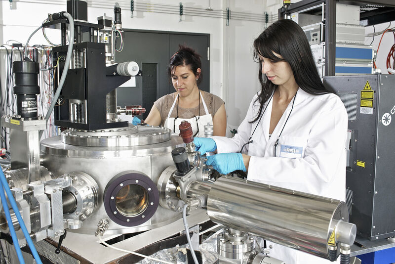 Die Forscherinnen Claudia Cancellieri und Mathilde Reinle-Schmitt an einer Anlage, an der mithilfe eines Lasers dünnen Schichten von unterschiedlichen Materialien hergestellt werden können. (Bild: Paul Scherrer Institut/M. Fischer)
