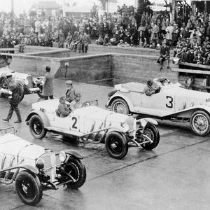 Die „Weißen Elefanten“ von Mercedes beim Eröffnungsrennen des Nürburgrings 1927. Dierses gewann Rudolf Caracciola. Er befand die erste Gebirgs-, Renn- und Prüfungsstrecke mit ihren vielen Kurven, Gefällen und Sprunghügeln als „bärig schwer“. (Bild:   Nürburgring 1927 GmbH & Co. KG)