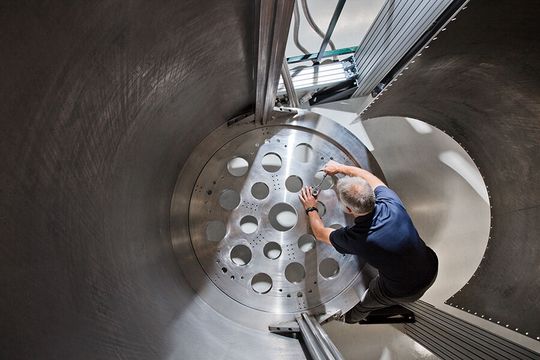 Pat Gumann, Manager of Quantum Processor & System Integration bei IBM Quantum, justiert den Boden eines „Superkühlschranks“, des größten Verdunstungsapparates der Welt. (Bild:  IBM)