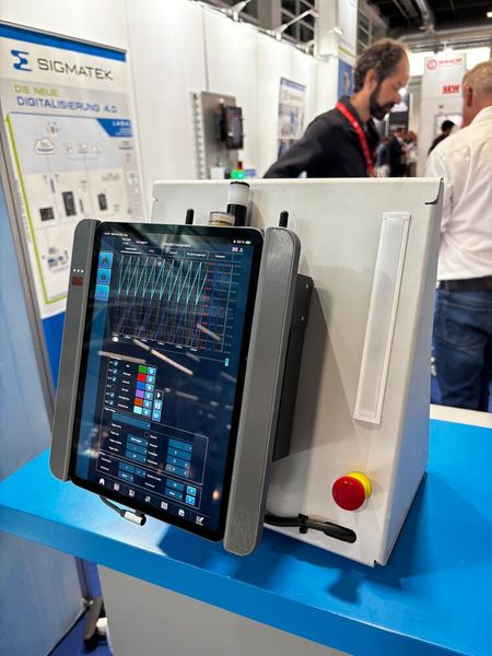 Sigmatek hat ein neues portables Wireless Safety Bediengerät gezeigt. Das mobile Bediengerät kombiniert drahtlose Sicherheitsfunktionen mit einer smarten Tablet-Halterung für die HTML5-basierte Visualisierung. Integrierte Sicherheitselemente wie Not-Halt und beidseitige Griffleisten ermöglichen eine sichere Bedienung direkt vor Ort an der Maschine, während das eingesetzte Tablet flexible, softwarebasierte HMI-Oberflächen mit Slidern, Buttons und weiteren Bedienelementen darstellt und verbindet so klassische Maschinensicherheit mit moderner, portabler Visualisierungstechnik für den Maschinen- und Anlagenbau. (Bild: Jeremy Streiff)