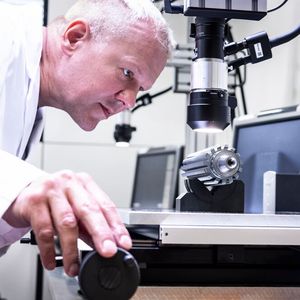 Hier hat ein Experte die Kantenradien eines Verzahnungswerkzeugs voll im Prüferblick. Laut Oerlikon Balzers ist es dabei nicht trivial, von Produkt zu Produkt, vergleichbare Ergebnisse zu erhalten. Das Nassstrahlen der Werkzeuge kann aber helfen.(Bild:  P. Fuchs / Oerlikon Balzers)