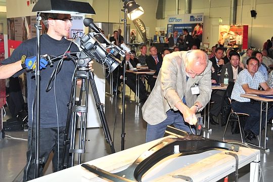 Bei einem Vortrag versucht Moderator Karl Damschen mit vollem Körpereinsatz, eine B-Säule aus höchstfestem Stahl zu zerstören – erfolglos. (Archiv: Vogel Business Media)