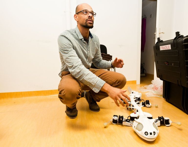 Nyakatura macht sich mit der Funktionsweise des Pleurobot vertraut. Der bionische Roboter wurde an der schweizerischen Ingenieursschule École Polytechnique Fédéral Lausanne entwickelt und kann die Fortbewegung von Salamandern perfekt imitieren. (Daimler und Benz Stiftung/Oestergaard)