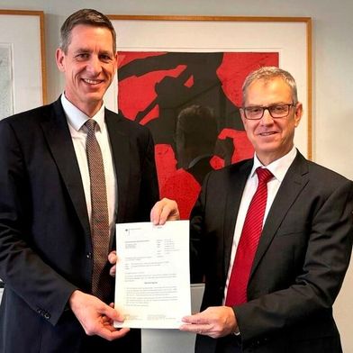 Stefan Bögl (l.) bekommt vom Präsidenten des Eisenbahn-Bundesamtes Stefan Dernbach die Betriebsgenehmigung übergeben. (Bild: Max Bögl)