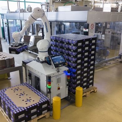 Der Cobot entnimmt die Trays aus dem vorgeschalteten Packer, setzt sie 
auf Paletten um und fügt selbstständig Karton-Zwischenlagen ein.  (Bild: Yaskawa Europe GmbH)