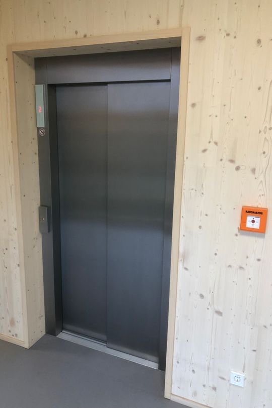 (Ein Aufzugsschacht aus Holz, vor der Aufzugstür. Foto: Schindler)
