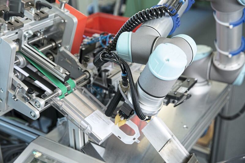 Die Roboter von UR werden bei Jung auch als Stand-alone-Geräte eingesetzt – zum Beispiel beim Verpacken und Etikettieren.  (Universal Robots)