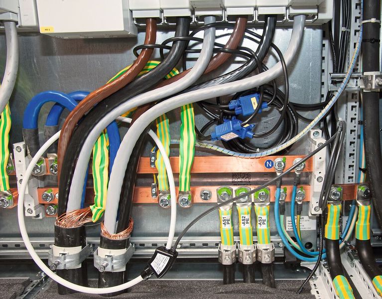Bild 5: Rogowski-Spulen lassen sich leicht nachträglich installieren – auch wenn es eng wird. Die schwarzen Spulen oben in der Bildmitte erfassen die Ströme der einzelnen Phasen. Die weiße Spule links dient zur Differenzstrommessung. (Bild: M. Witzsch)