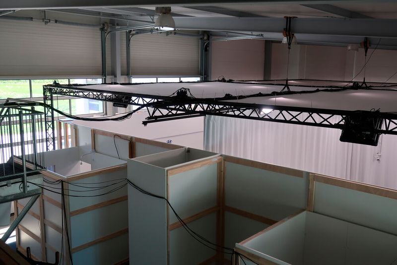 Zwischen den Bereichen hängt ein schwerer weißer Vorhang, der die Geräusche der Nebenkabinen dämmen soll. Oberhalb sind zahlreiche Strahler angebracht. (Bild: Viktoria Hahn / »kfz-betrieb«)
