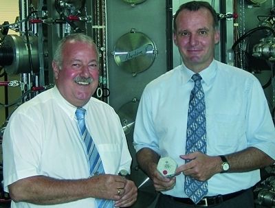 Gustav Adlhoch (links), kaufmännischer Geschäftsführer der Intellifast GmbH, Speyer, und sein Kollege, der technische Geschäftsführer Frank Scheuch, vor der  Sputteranlage. Bild: Intellifast (Archiv: Vogel Business Media)