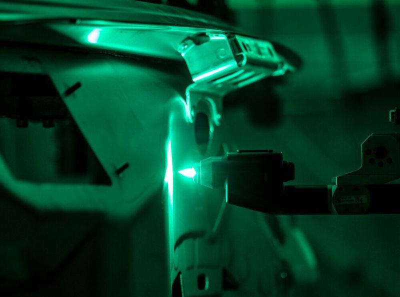 Die reinigende Plasmaflamme des Fronius-Acerios-Systems in Aktion an einem Audi-Bauteil aus Aluminium. Punktgenau wird hier gereinigt, also nur dort, wo es für das spätere Bolzenschweißen unbedingt nötig ist. (Fronius)