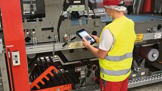 Tim Pflaum rüstet den Traypacker mit Hilfe einer digitalen Checkliste und Anleitung um.  (Bild: Coca Cola)