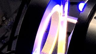 Blick auf ein Gemisch aus Katalysator und Wasser (senkrechte Röhre), das von gelbem und blauem Licht angeregt wird. Forschende am LIKAT erkennen darin eine Alternative, um grünen Wasserstoff zu erzeugen. (LIKAT / J. Schneidewind)