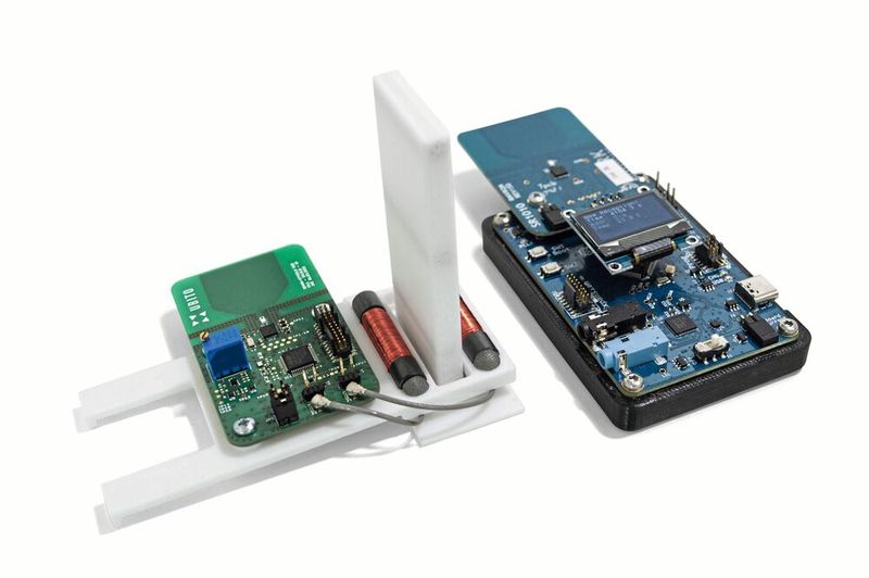 Durchbruch im Labor – IIoT Sensorknoten auf Wiegand-Basis. Links: Die beiden Wiegand-Harvester zwischen den Stabmagneten (unter der weißen Umhausung) und die Sende-Platine mit Mikrocontroller, Temperatursensor und UWB-Sendemodul. Rechts: Die bis zu 60 m entfernte Empfängerstation, welche die Daten per Funknetz einsammelt und als Gateway am Strom angeschlossen ist. (Bild: Posital)