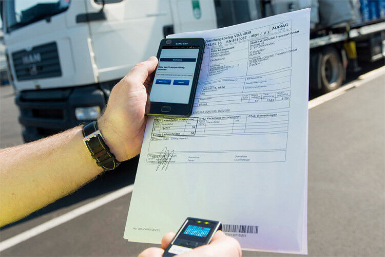 Sobald der Lkw beim Lieferanten beladen wird, scannt der Fahrer den Lieferschein in sein Smartphone ein und schickt ihn samt den Fahrzeugdaten an die Leitstelle von Audi. (Foto: Audi)