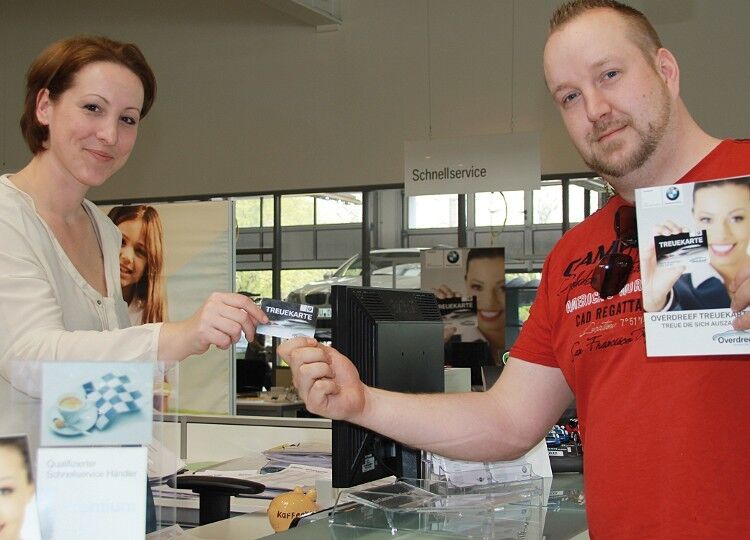 Aleksandra Ristic, die das Marketing im BMW-Autohaus Overdreef verantwortet, übergibt einem Kunden die Treuekarte. (Foto: Overdreef)