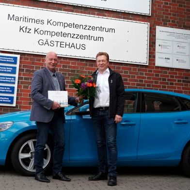 Jens Giese (links) dankt Marcus Engler für die Spende des Volvo V40. (Bild: HWK Lübeck)