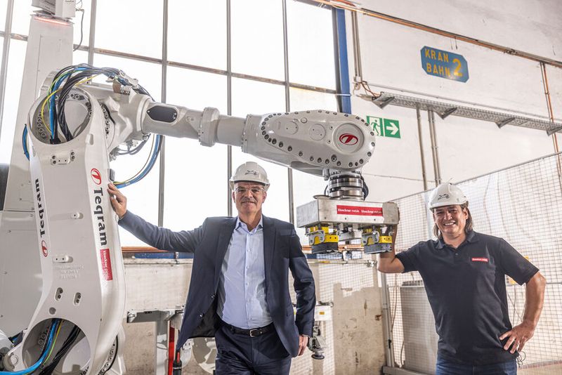 Endlich sind die Mitarbeiter von der schweren und nicht zuletzt auch gefährlichen Aufgabe des Entgratens erlöst. Den das macht jetzt dieser besondere Roboter. Von links: Es freuen sich der Kloeckner-Metals-Germany CEO Bernhard Weiß und der Regionalleiter Ost. (Bild: www.industriefotografie-steinbach.de)