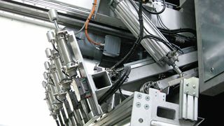 Blickfang der pfiffigen Kunststoffaufbereitungsanlage von Getecha: Parallelogramm-Greifschieber (hier in Ruheposition) mit integrierter Messsensorik zum vollautomatischen Zuführen gestapelter Polypropylenplatten zur Zerkleinerungsmühle.  (Stöcker)