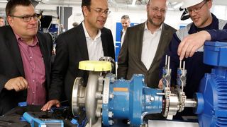 Stefan Pfitzner, Mitarbeiter der Infraserv Höchst Prozesstechnik, erläutert den Infraserv-Geschäftsführern Jürgen Vormann (2. v.r.) und Dr. Joachim Kreysing (2. v.l.) im Beisein von Frank Unger, Geschäftsführer Infraserv Höchst Prozesstechnik, an einem Pumpenaggregat, wie mithilfe der Lasertechnik die korrekte Ausrichtung erfolgt und wie Datenbrillen eingesetzt werden.  (Maik Reuß/Infraserv Höchst)