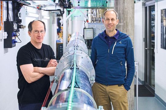 Andreas Wallraff und Renato Renner neben der 30 Meter langen Verbindung zwischen zwei Quantenchips. Mit dem Experiment erzeugten die ETH-Forscheer erstmals nach eigener Aussage zertifiziert perfekte Zufallszahlen.(Bild:  Kilian Kessler / ETH Zürich)