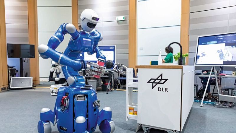 Der humanoide DLR-Roboter Rollin‘ Justin hat die Müslischachtel auf dem Tisch erkannt und stellt sie selbstständig wieder zurück an ihren Platz im Schrank. Seine nachgiebig geregelten Gelenke stellen sicher, dass er sicher und präzise mit seiner Umgebung interagiert. Wissensgestützte KI und moderne Lernverfahren ermöglichen Rollin‘ Justin dabei eine zuverlässige, autonome Aufgabenausführung. (Bild: DLR (CC BY-NC-ND 3.0))