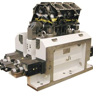 Hydraulisch betätigte Vorrichtung zum Spannen von Zylinderblöcken: Hydraulisch betätigte, um 31°schwenkbare Spannvorrichtung – 505 mm hoch, 973 mm lang und 420 mm breit, mit 2 starren und 2 pendelnden Werkstückauflagen mit Luftanlagekontrolle, Werkstückausrichtung über ein 2-Backen Ausrichtfutter und 2 Bolzenspanndornen und Planspannung mit 2 Schwenkspannern, zum Spannen von Motorblöcken.  Bilder: Röhm