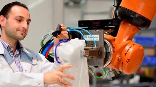 Gute Zusammenarbeit: Der Roboter übergibt dem Menschen ein Bauteil. (Foto Fraunhofer IWU)