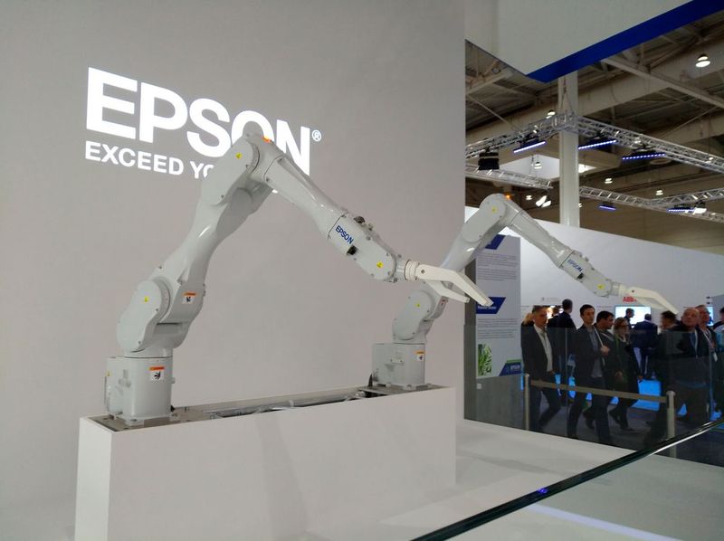 Zur Showeinlage tanzen zwei Roboterarme, beleuchtet von mehreren Epson-Beamern. (Bild: Robert Horn)