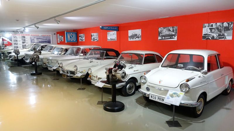Auch im Untergeschoss überwiegt in der Ausstellung die Marke NSU. Besonders in der Nachkriegszeit war das Unternehmen für seine motorisierten Zweiräder sehr beliebt und zeitweise sogar der weltgrößte Zweiradhersteller. Die Ausstellung vermittelt in ihrem didaktischen Aufbau den Stellenwert des Individualverkehrs in der Zeit des Wirtschaftswunders. Dies wird besonders anhand der chronologisch präsentierten, kompletten Automobilbaureihe der Neckarsulmer Motorenwerke veranschaulicht. Um das Größenwachstum der Fahrzeuge über die Jahre zu demonstrieren, wurde nur weiße Exemplare angeschafft bzw. diese weiß lackiert. Das schließt den Einfluss der Farbe auf den Betrachter aus. (Bild: Dominsky – VCG)