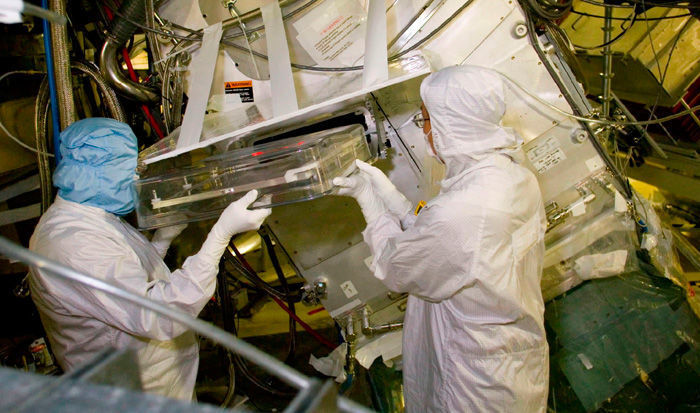 NIF-Mitarbeiter bringen einen Schutzschild von einem optischen Messgerät an, dass zur Beobachtung der Laser-Schüsse dient (Archiv: Vogel Business Media)