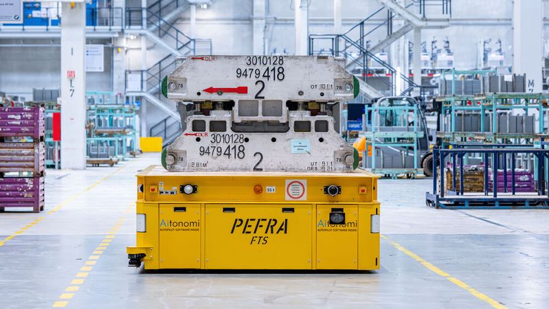 Im BMW Werk Regensburg navigiert ein autonomes Transportfahrzeug präzise durch das Presswerk.(Bild:  BMW Group)