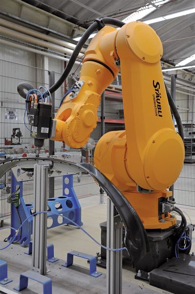 Bild 1: Der Roboter erledigt die komplette Bearbeitung der Frontschürzen in hoher Genauigkeit. (Bild: Stäubli)