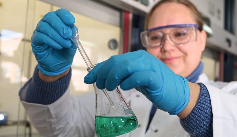 Zur Demonstration des ersten Schrittes der Synthese des neuen Katalysatormaterials tropft Anna Wolf eine Base zu einer Metallsalzlösung. In dem dabei entstehenden Feststoff sind Nickel und Magnesium bereits auf atomarer Ebene vermischt. (Bild:  Christina Anders, Uni Kiel)