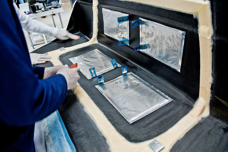 Im Bild werden mehrere Super-Kondensator-Laminierungen auf der Kofferraumklappe aus dem leichten Kohlefaser-Werkstoff angebracht. (Foto: Volvo)