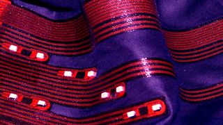 Smarte Textilien bieten für den Träger viele Vorteile: Auf dem Fachkongress im November tauscht sich die Branche aus. Das Bild zeigt Leuchtdioden, die nicht auf einer Platte oder einem Streifen sitzen, sondern auf einem weichen Stück Stoff. Entwickelt vom Fraunhofer IZM. (Bild: Fraunhofer IZM)