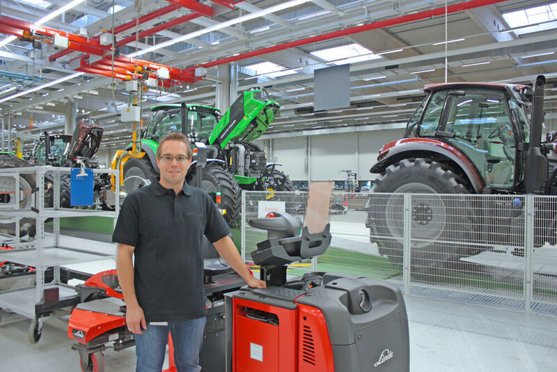 Michael Götz, Warehouse Manager Same-Deutz-Fahr , mit dem Routenzug „Factory Train“ an der Traktoren-Montagelinie im Werk in Lauingen. (Neumaier)
