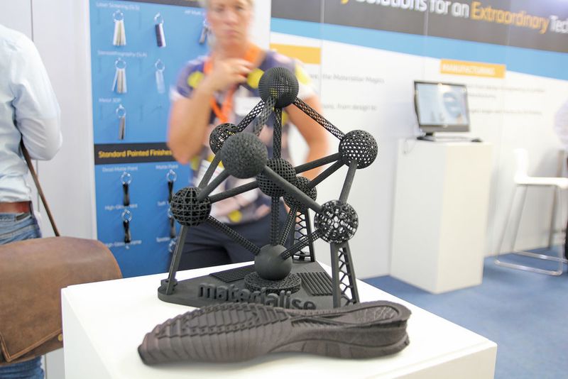 Auf dem Bild sind Exponate von Materialise zu sehen: ein Atomium und eine Schuhsole. Beide wurden mit dem Multi Jet Fusion von HP gedruckt, der mit dem Build-Prozessor von Materialise ausgestattet ist. Mit der Software Magics wurden die Daten für den Druck vorbereitet. (Simone Käfer/MM)