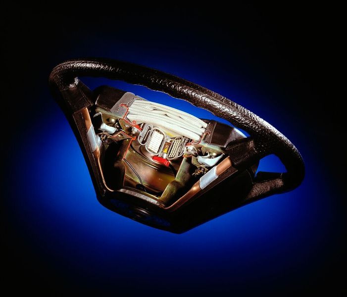 Schnittbild eines Airbaglenkrads aus dem Jahr 1992. Über dem Treibsatz ist der zusammengelegte Airbag (weiß) zu erkennen. (Mercedes-Benz AG)