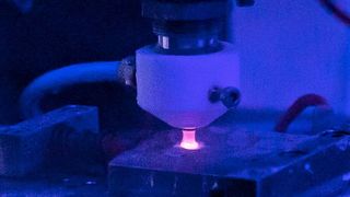 Forscher haben das Polieren von Metalloberflächen mit Plasma weiterentwickelt. Der neuartige Jet-PEP-Prozess (plasmaelektrolytisches Polieren) macht die Maskierung gewisser Bauteilsektionen, wie sie beim normalen PEP nötig ist, überflüssig. Hier sieht man den Bearbeitungskopf, wie er eine plane Oberfläche poliert. (TU Chemnitz)