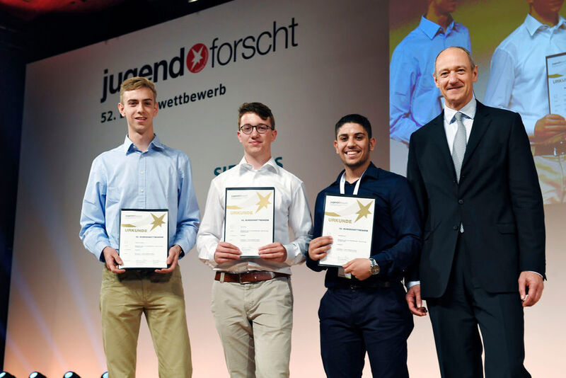 Roland Busch vergibt den Preis im Fachgebiet Arbeitswelt an Albrecht von Bülow, Flavio Krug, Saeed Mohamad aus Marburg (von links).  (Siemens)