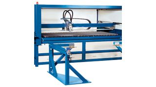 Die Laserschneidmaschine Laser-Jet mit davor stehendem Aufliege-Gestell für das Herausziehen des Schneidtisches, abgebildet mit für die Beschickung hochgezogenem Front-Segmenttor. (Bild: Knuth)
