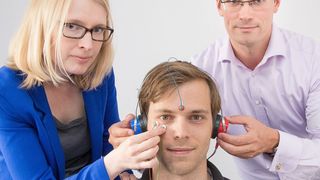 Im Schlaflabor: Dr. Nadine Petrovsky und Prof. Dr. Ulrich Ettinger vom Institut für Psychologie der Universität Bonn bestimmen bei einem Probanden (m.) mit der Präpulsinhibition die Filterfunktion des Gehirns. (Bild: Foto: Volker Lannert/Uni Bonn)