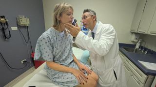 Dr. Pedram Gerami examines the skin of patient and melanoma survivor Heidi Tarr
 (Source: Ben Schamisso / Northwestern University)